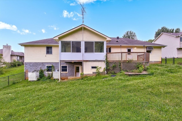 rear view of house featuring a wooden deck, a yard, a sunroom, and a wall unit AC