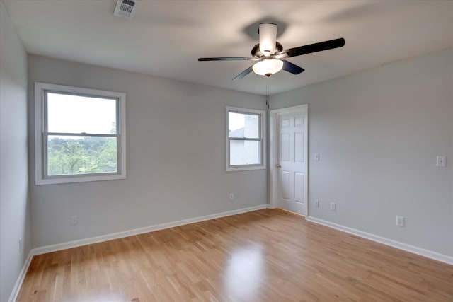 unfurnished room featuring ceiling fan, a healthy amount of sunlight, and light wood-type flooring