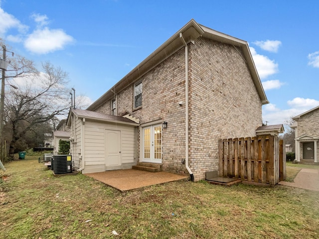 rear view of property featuring cooling unit, a patio area, and a lawn