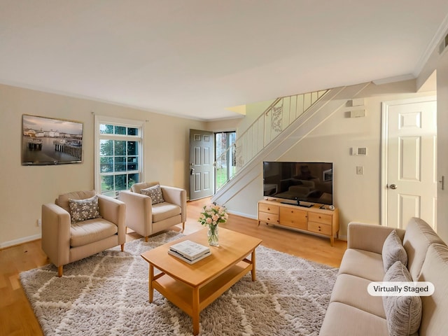 living room featuring hardwood / wood-style flooring, a wealth of natural light, and ornamental molding