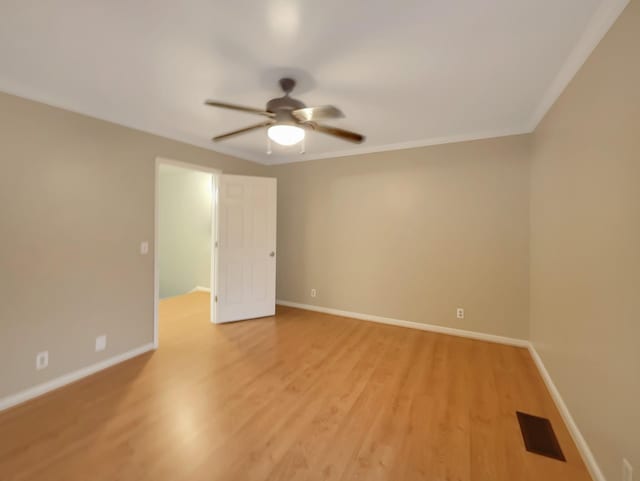 spare room with crown molding, ceiling fan, and light wood-type flooring