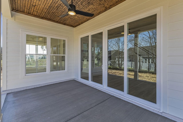 unfurnished sunroom featuring wooden ceiling and ceiling fan