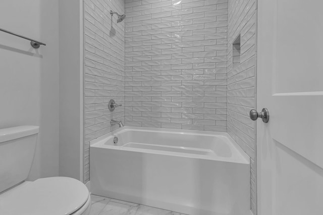 bathroom with tiled shower / bath combo and toilet