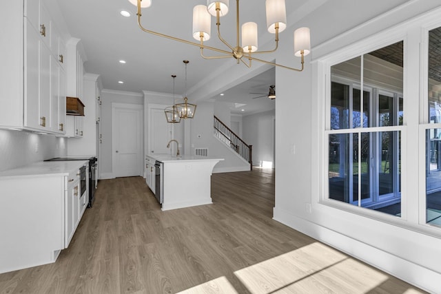 kitchen with pendant lighting, stainless steel dishwasher, a kitchen island with sink, and white cabinets