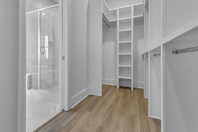 walk in closet with light wood-type flooring