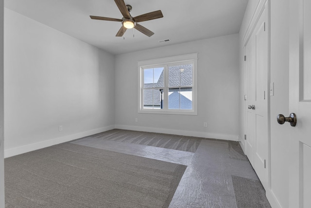 spare room with ceiling fan and carpet