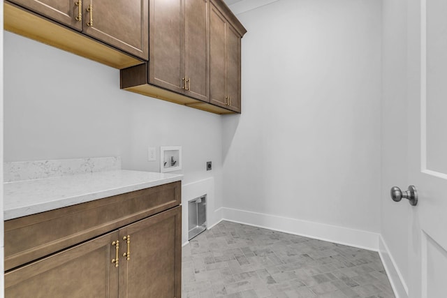 clothes washing area with hookup for a washing machine, cabinets, and hookup for an electric dryer