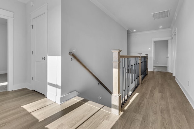 stairway with crown molding and hardwood / wood-style floors