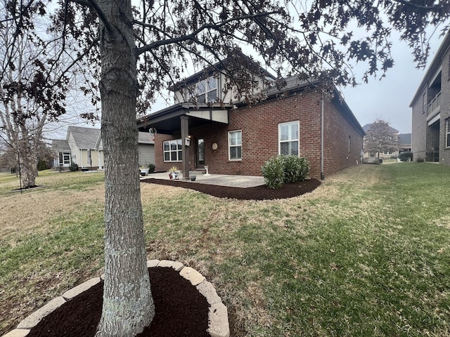 rear view of house featuring a lawn and a patio area