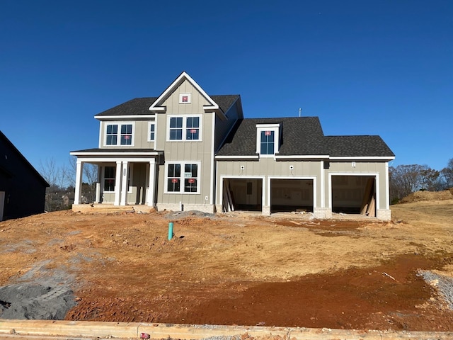 view of front facade featuring driveway, covered porch, board and batten siding, and roof with shingles