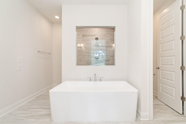 bathroom with a freestanding bath, tiled shower, recessed lighting, and baseboards