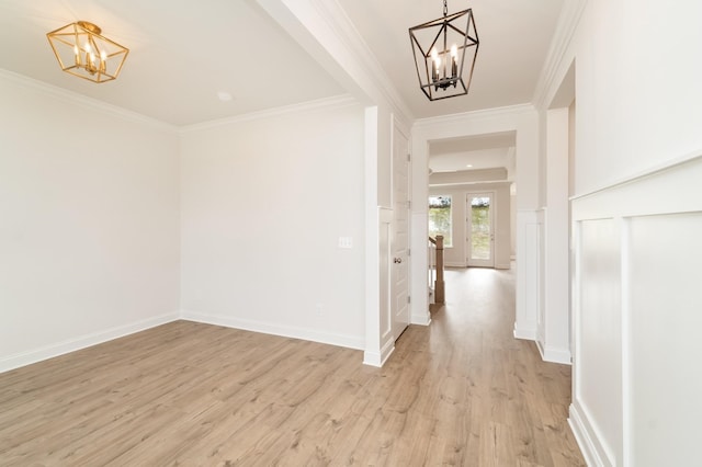 hallway with baseboards, ornamental molding, light wood-type flooring, and a notable chandelier