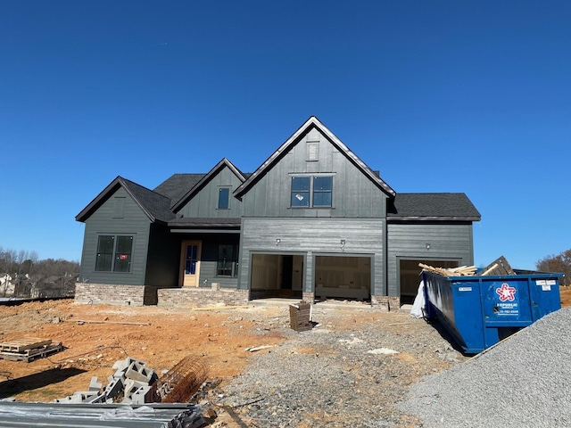 view of front of property with board and batten siding, an attached garage, and gravel driveway