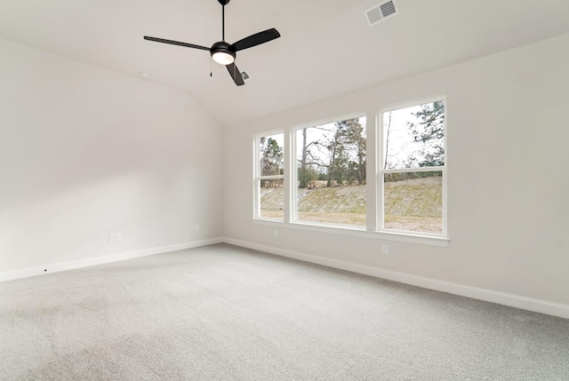 unfurnished room with baseboards, visible vents, ceiling fan, vaulted ceiling, and carpet floors