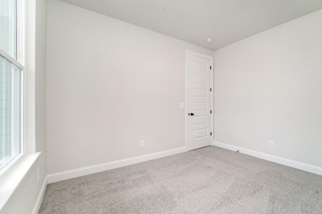 unfurnished room featuring carpet floors and baseboards