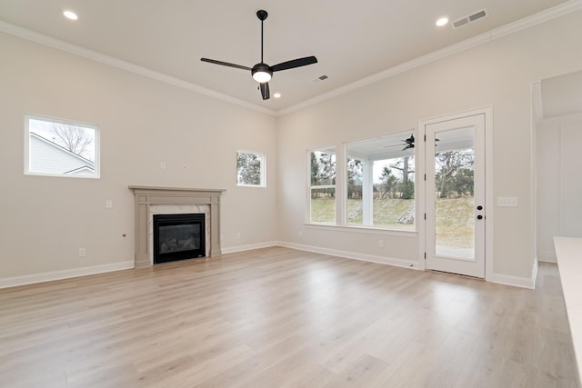 unfurnished living room with baseboards, visible vents, ornamental molding, light wood-style floors, and a high end fireplace