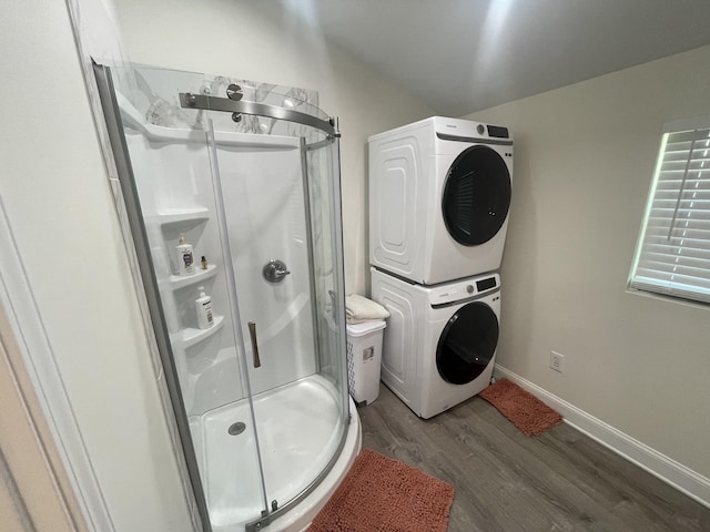 laundry room featuring stacked washer and dryer and hardwood / wood-style floors