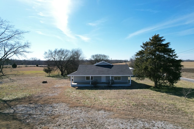 view of front facade featuring a rural view, a front yard, and covered porch