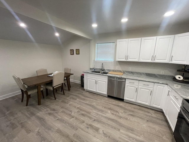 kitchen featuring vaulted ceiling, white cabinetry, dishwasher, sink, and light wood-type flooring