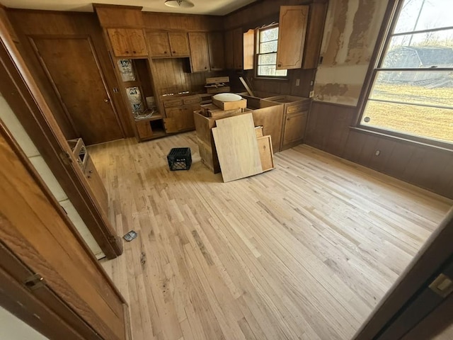 kitchen with wooden walls and light wood-type flooring