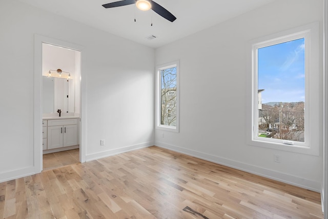 unfurnished bedroom featuring sink, connected bathroom, ceiling fan, and light hardwood / wood-style flooring