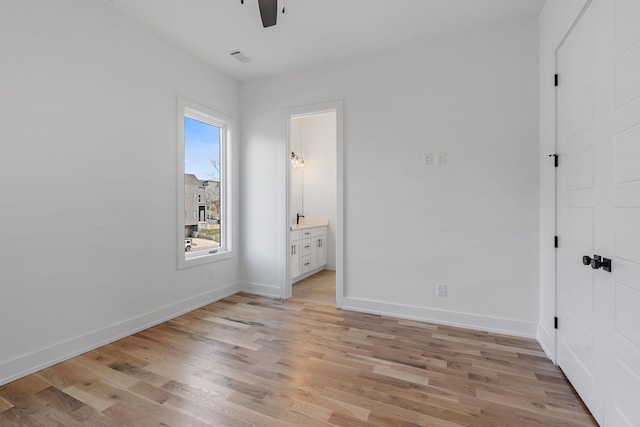 unfurnished bedroom with connected bathroom, light hardwood / wood-style flooring, and a closet