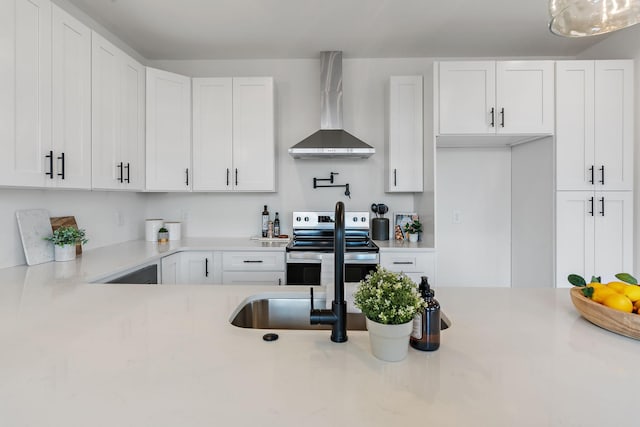 kitchen with electric stove, wall chimney range hood, and white cabinets