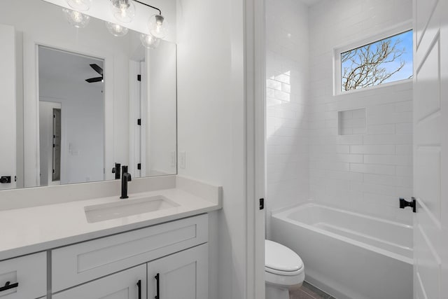 full bathroom featuring tiled shower / bath combo, vanity, and toilet