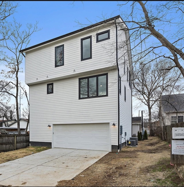 back of house featuring a garage and central air condition unit