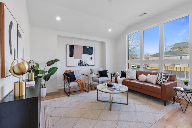 living room featuring vaulted ceiling and light wood-type flooring