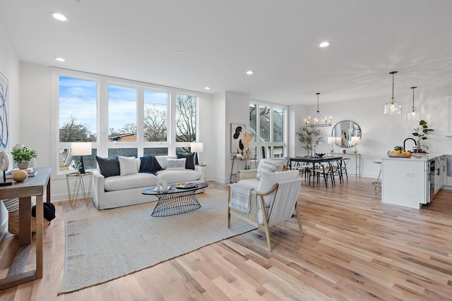 living room featuring an inviting chandelier and light hardwood / wood-style flooring