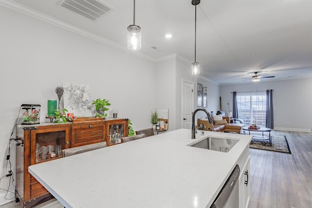 kitchen with an island with sink, decorative light fixtures, dishwasher, and sink