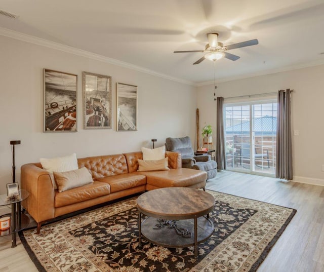 living room with ornamental molding, wood-type flooring, and ceiling fan