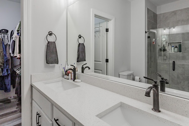 bathroom featuring vanity, toilet, and an enclosed shower