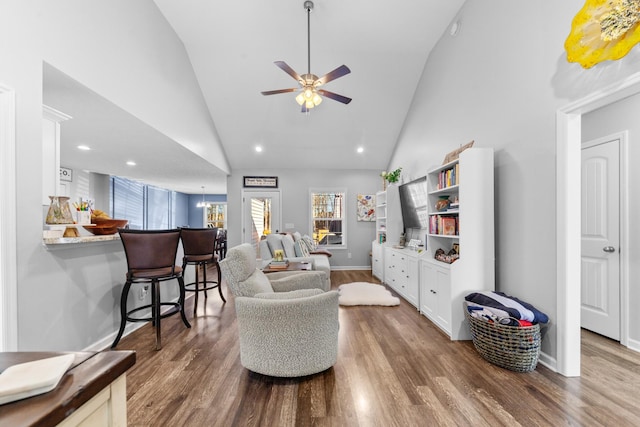 living room featuring dark wood-type flooring, ceiling fan, and high vaulted ceiling