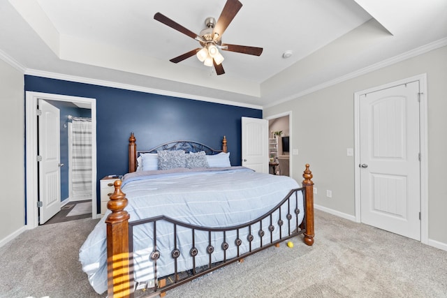 carpeted bedroom with crown molding, a tray ceiling, and ceiling fan