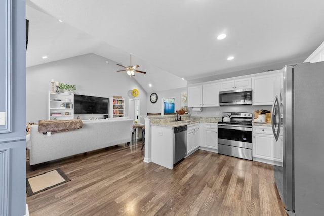 kitchen featuring white cabinetry, lofted ceiling, dark hardwood / wood-style flooring, kitchen peninsula, and stainless steel appliances