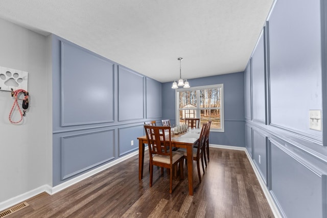 dining room featuring dark hardwood / wood-style floors and a chandelier