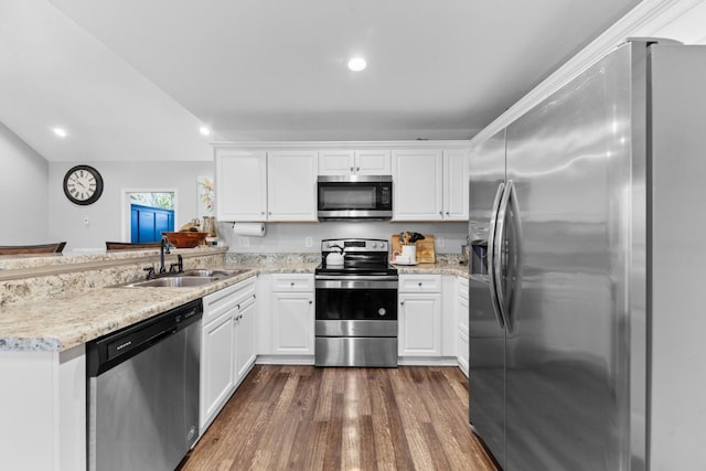 kitchen featuring sink, white cabinetry, appliances with stainless steel finishes, dark hardwood / wood-style floors, and kitchen peninsula