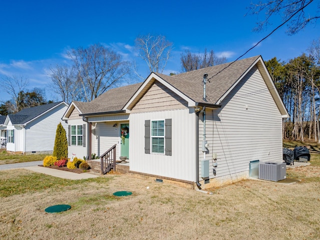 view of front of property with a front yard and central air condition unit