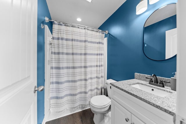 bathroom with wood-type flooring, curtained shower, vanity, and toilet