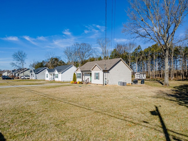 exterior space with a yard, cooling unit, and a storage unit