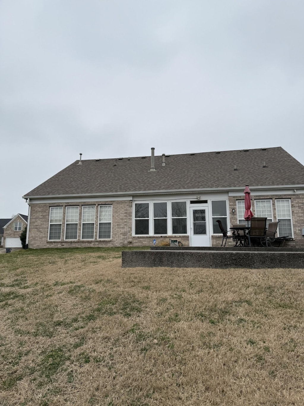 rear view of property featuring a patio and a lawn