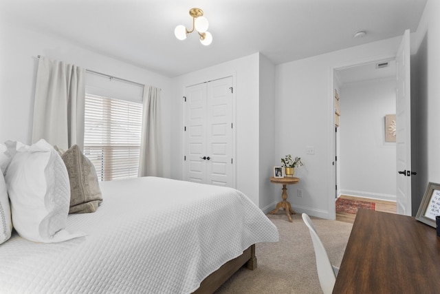 bedroom featuring carpet flooring, a notable chandelier, and a closet