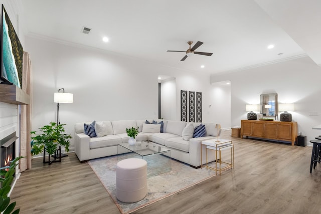 living room featuring crown molding, hardwood / wood-style flooring, and ceiling fan