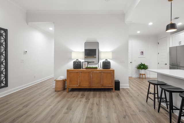 home office with ornamental molding and light hardwood / wood-style flooring