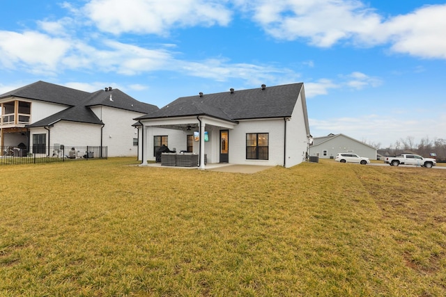 rear view of property with outdoor lounge area, a patio area, and a lawn