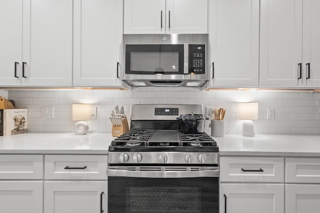 kitchen with tasteful backsplash, white cabinetry, and appliances with stainless steel finishes