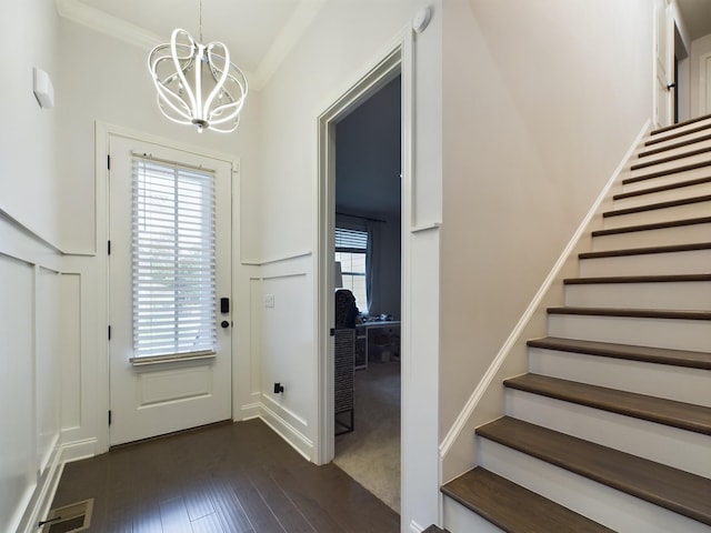 doorway to outside with plenty of natural light, dark hardwood / wood-style floors, and a chandelier