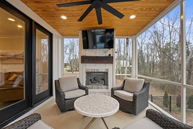 sunroom / solarium with wood ceiling and an outdoor fireplace